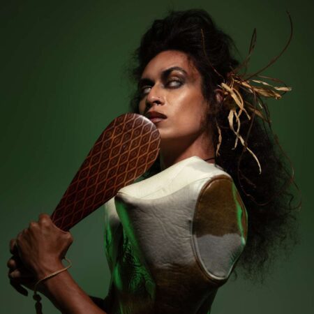 Jamaica Moana Jamaica Moana facing sideways and looking sideways with an object in their hand